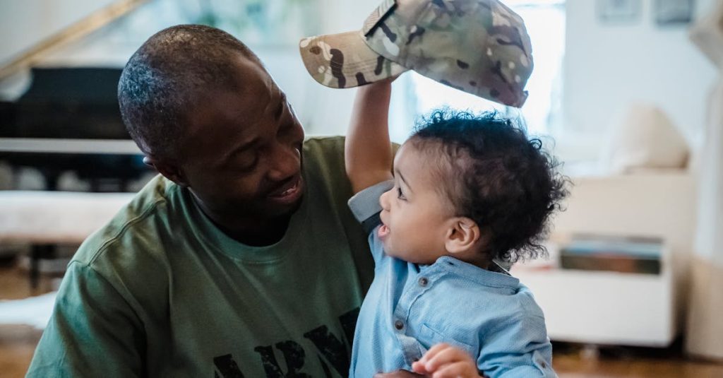 Joyful bonding moment of father and son, playing with military cap indoors, exuding love and happiness.
